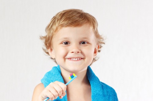 Young cute blond boy with toothbrush with pink toothpaste